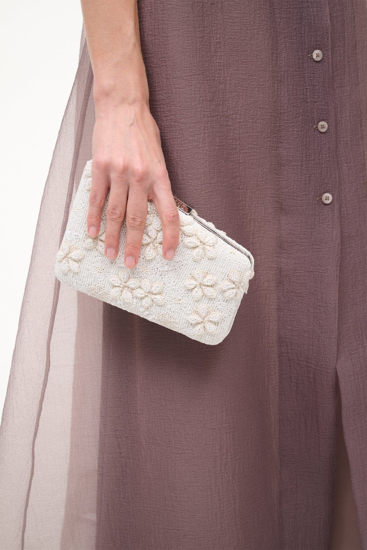 Cream beaded clutch purse with embossed floral design and top handle