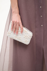 Cream beaded clutch purse with embossed floral design and top handle