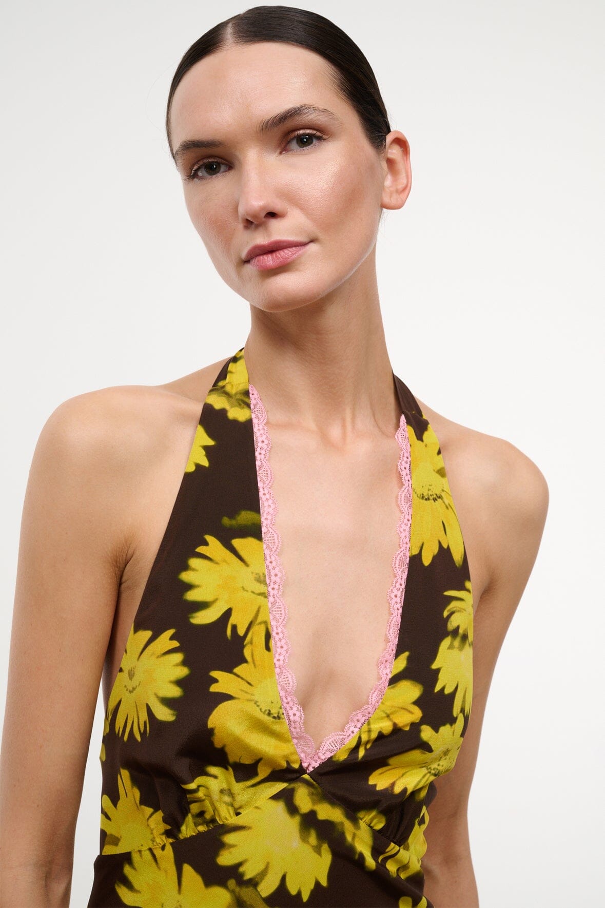 Floral halter dress with yellow daisies on black, pink-trimmed V neckline.