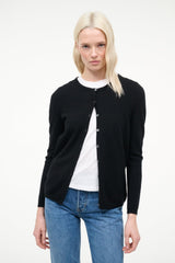 Black cashmere cardigan with open front showing white top and button placket