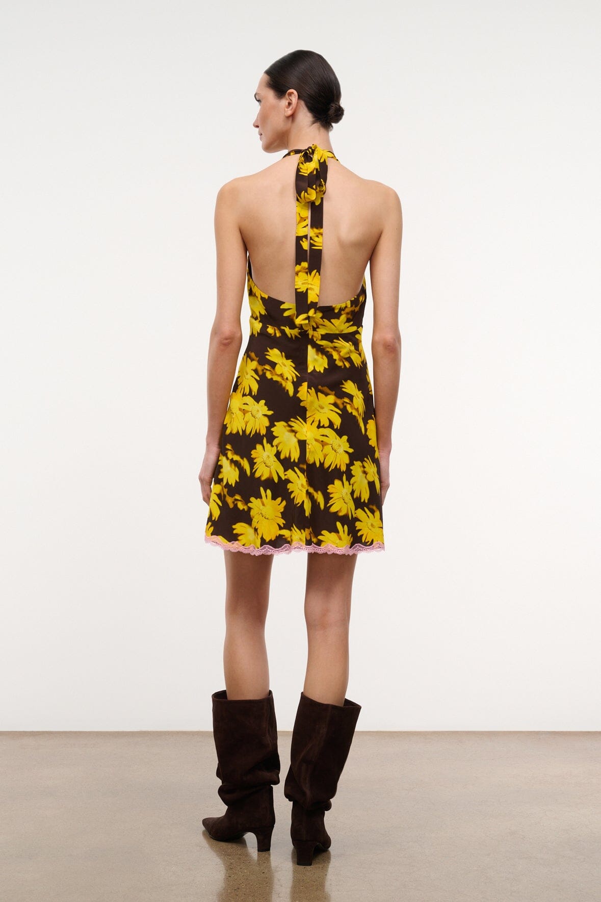 Back view halter mini dress with yellow daisy pattern and V-shaped open back