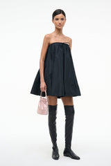 Blush mini handbag with short handle, held in hand.