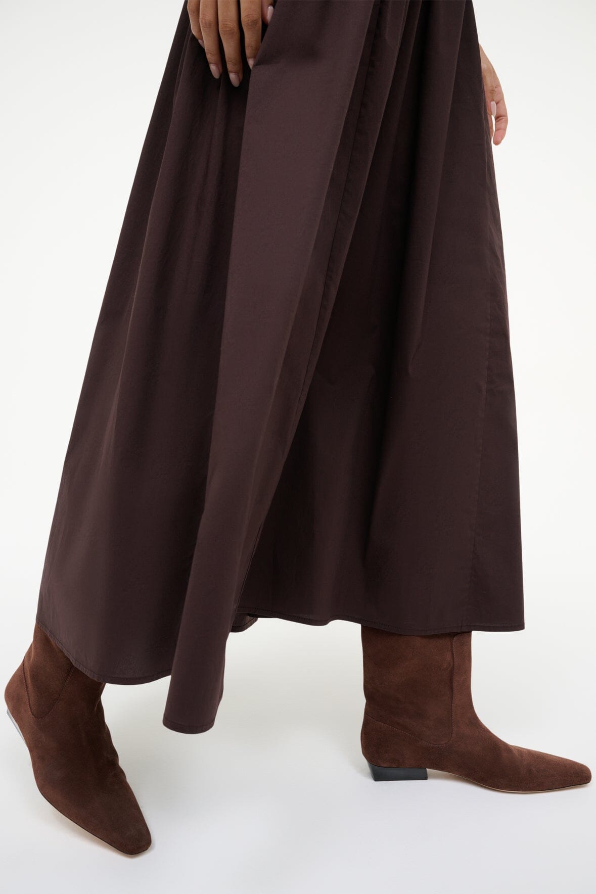 Wally flat suede boots in mahogany brown, worn with dress; low stacked heel visible.