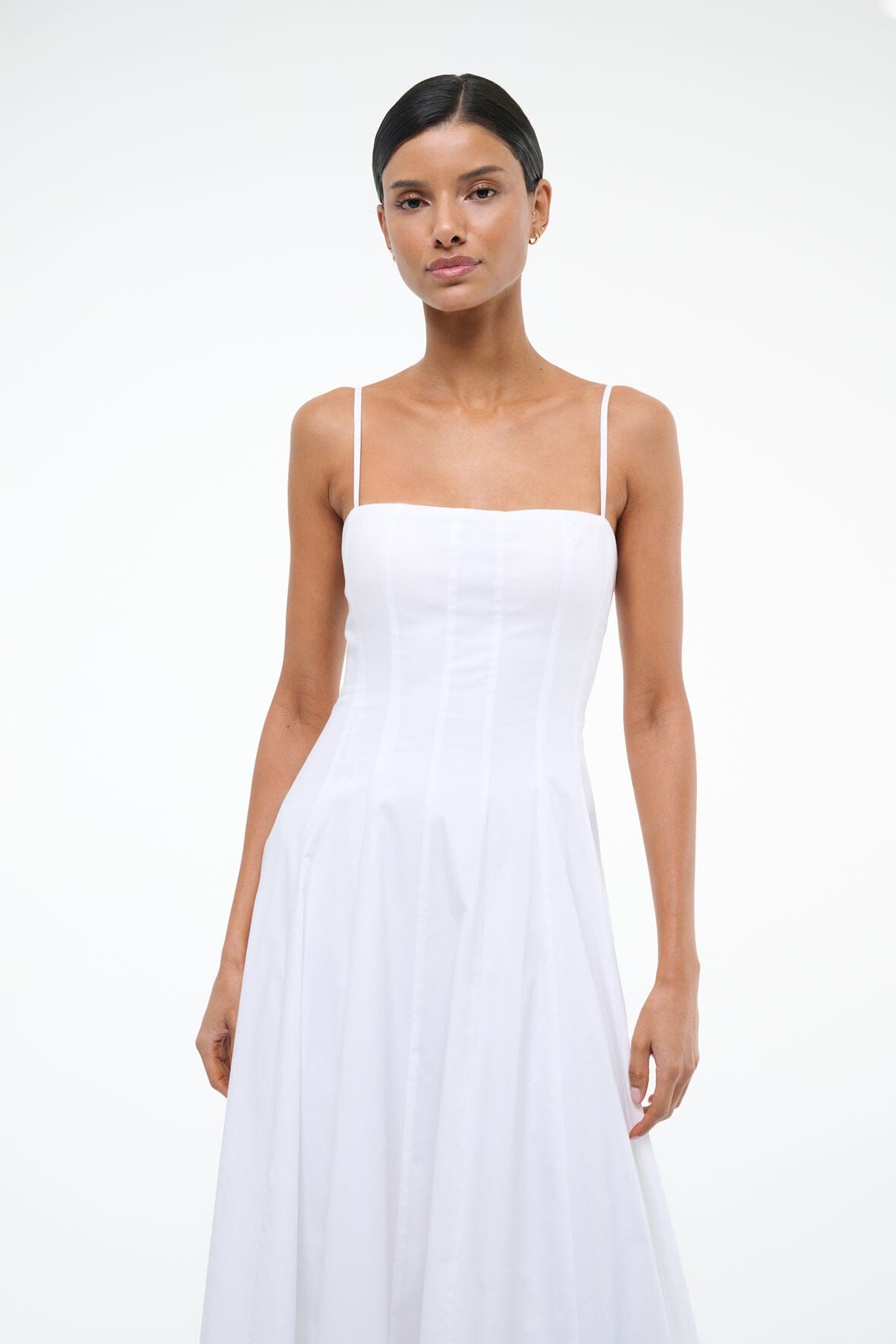 White maxi dress with square neckline and spaghetti straps, fitted bodice and gathered skirt
