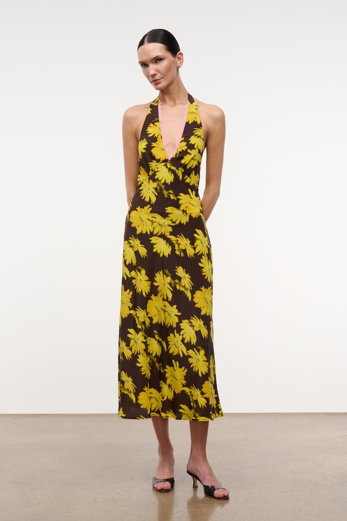 Floral halter midi dress with yellow daisy pattern and pink-trimmed V neckline.