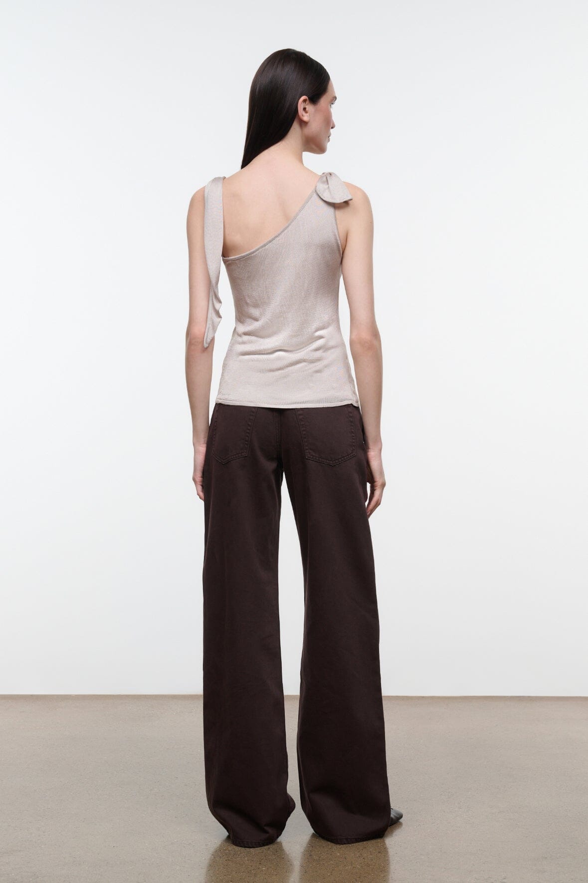 Back view of women's champagne sleeveless top with open scoop back and tied strap