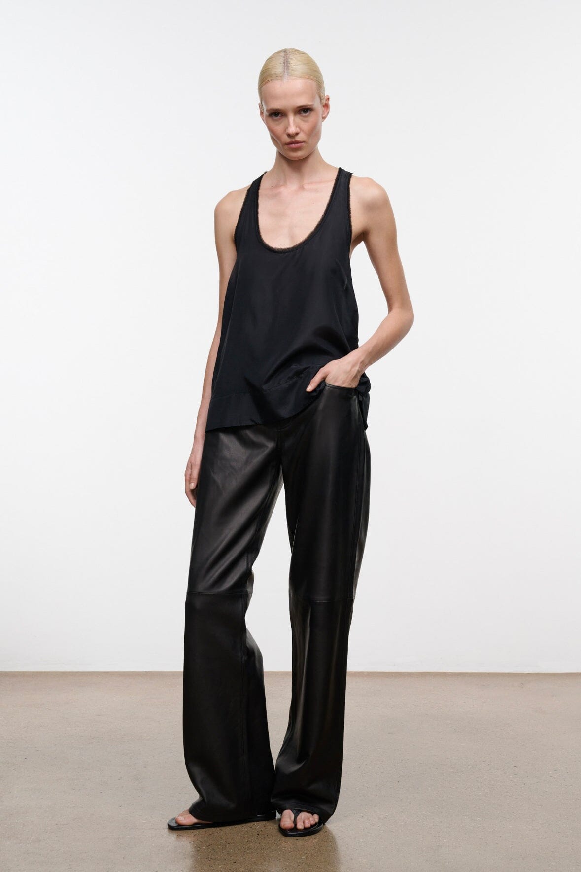 Black sleeveless tank top with scoop neckline, relaxed drape