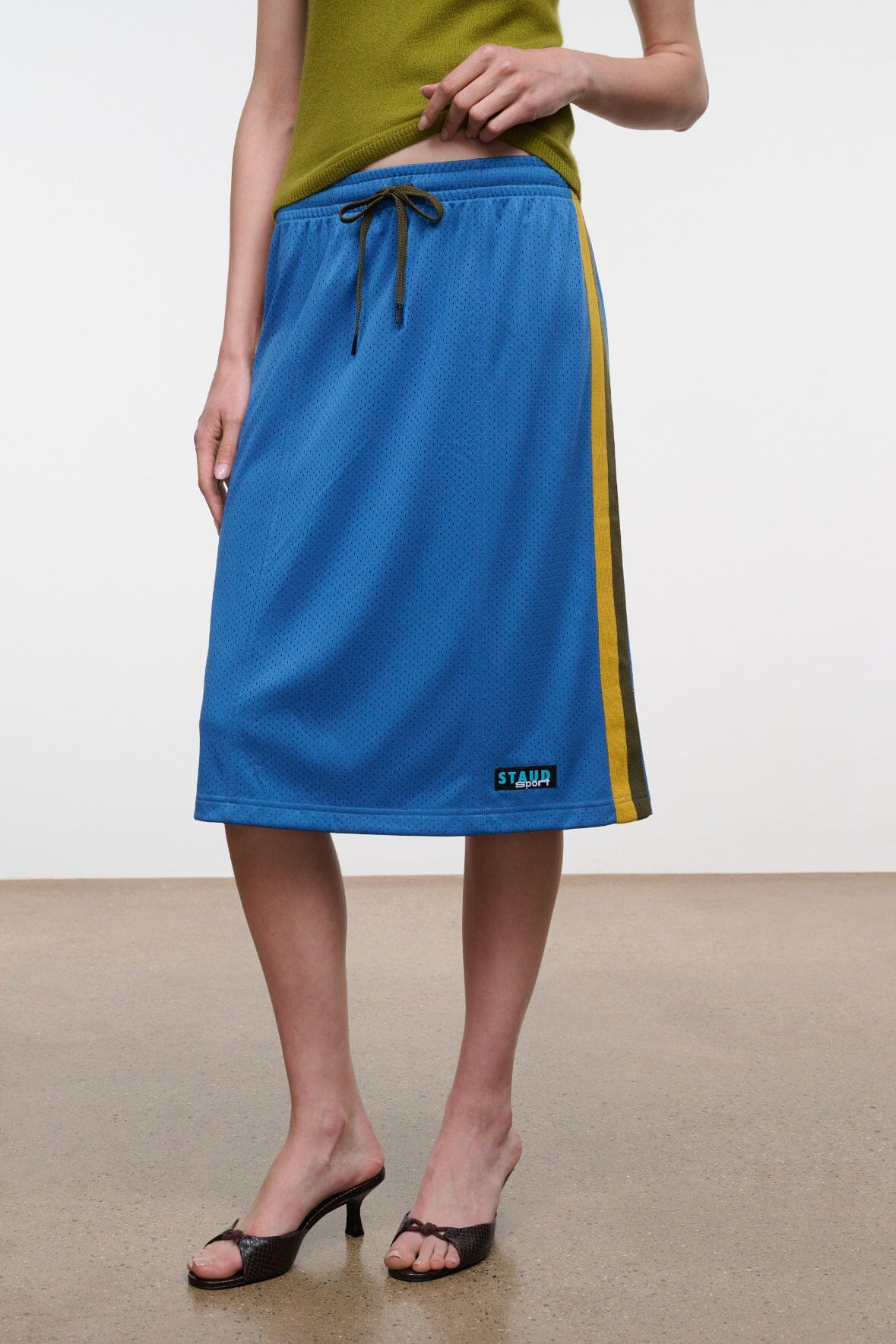 Blue midi skirt with olive trim stripe, elastic waist and drawstring; mid-calf length.