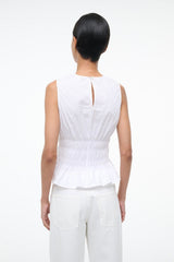 White sleeveless peplum top with back keyhole tie and smocked waist ruffle hem