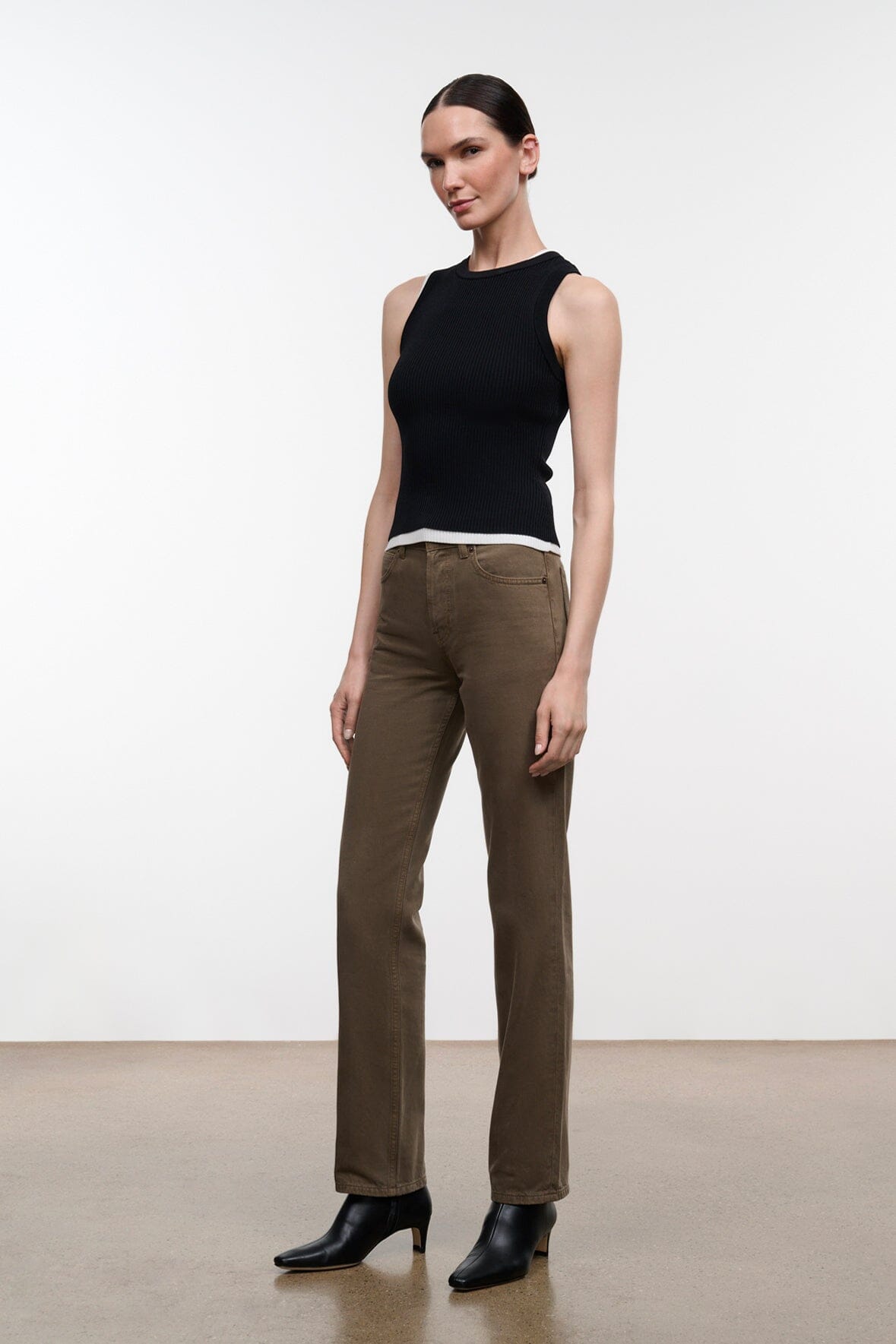 Greige straight-leg jeans on model with button fly, belt loops, and ankle hem
