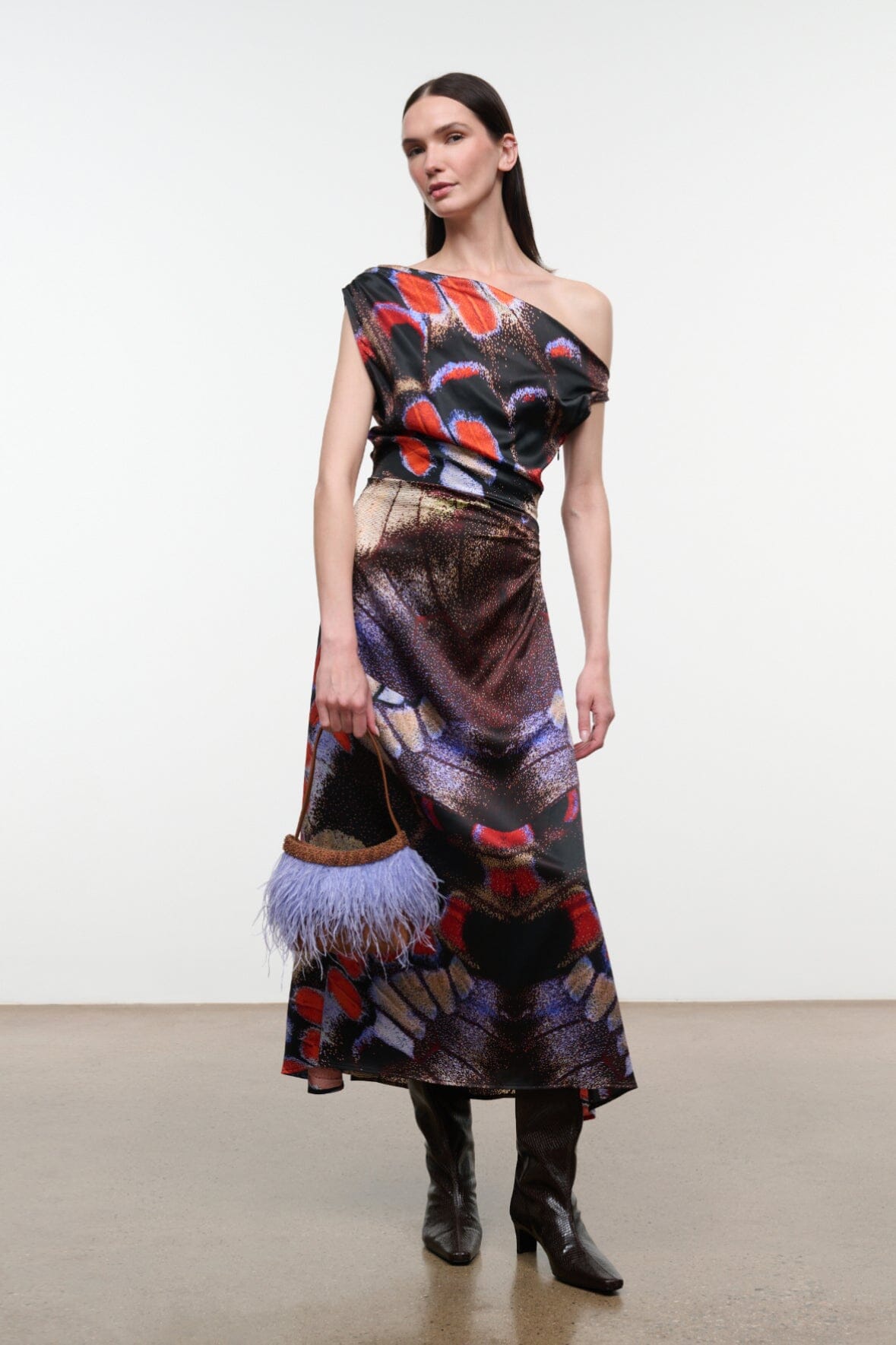 Knee-high dark espresso snake-embossed boot with low heel, worn with a dress.