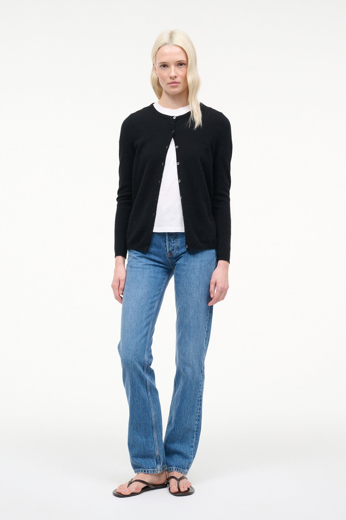 Black cashmere cardigan with button front and long sleeves, worn with jeans