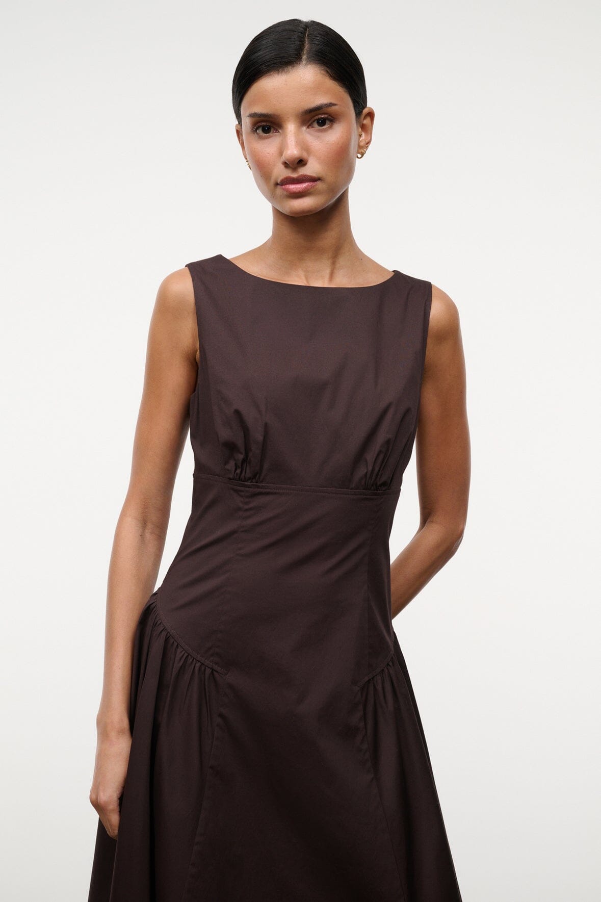 Brown sleeveless midi dress close-up, ruched waist and gathered skirt detail.