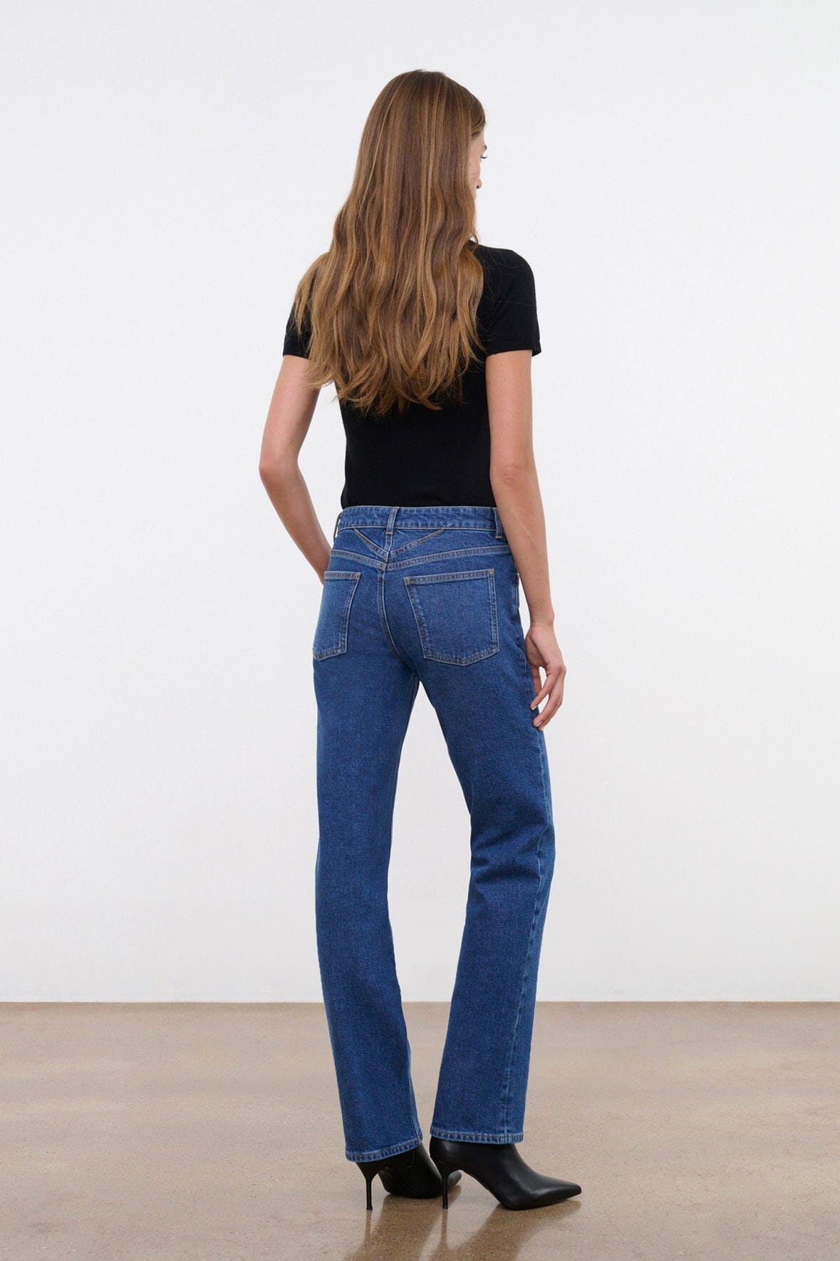Stone blue straight stretch jeans on model, back view, mid-rise