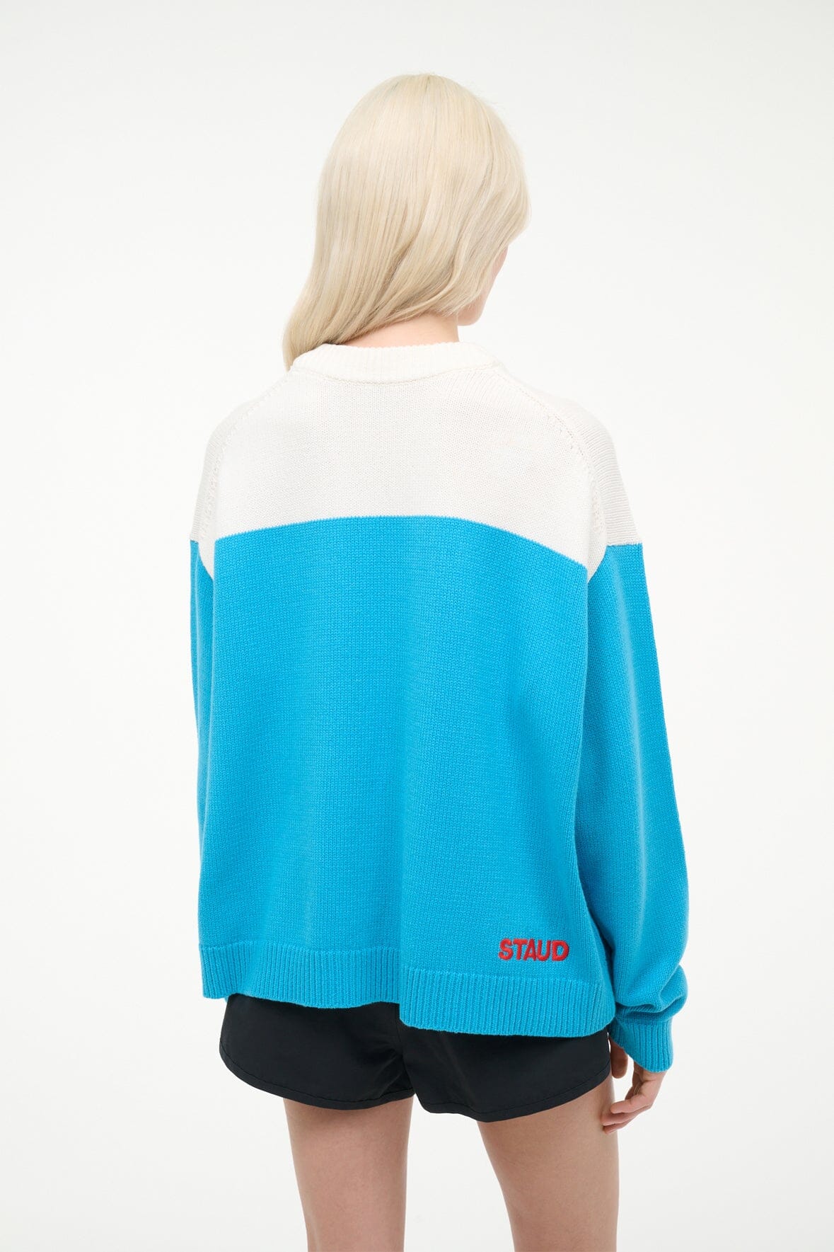 REYA sweater with white upper back, blue lower panel, and ribbed cuffs