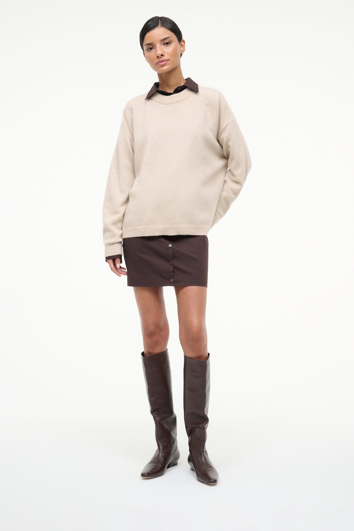 Tall espresso flat boots on model, pull-on style with low block heel