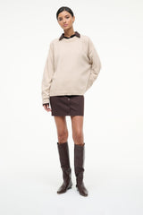 Tall espresso flat boots on model, pull-on style with low block heel