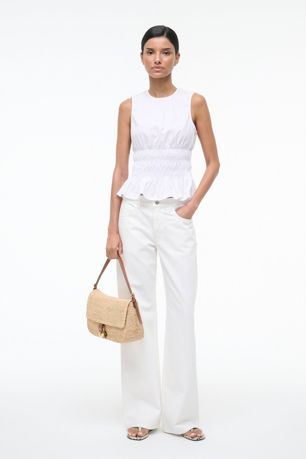 White sleeveless peplum top with round neckline and smocked waist ruffle hem