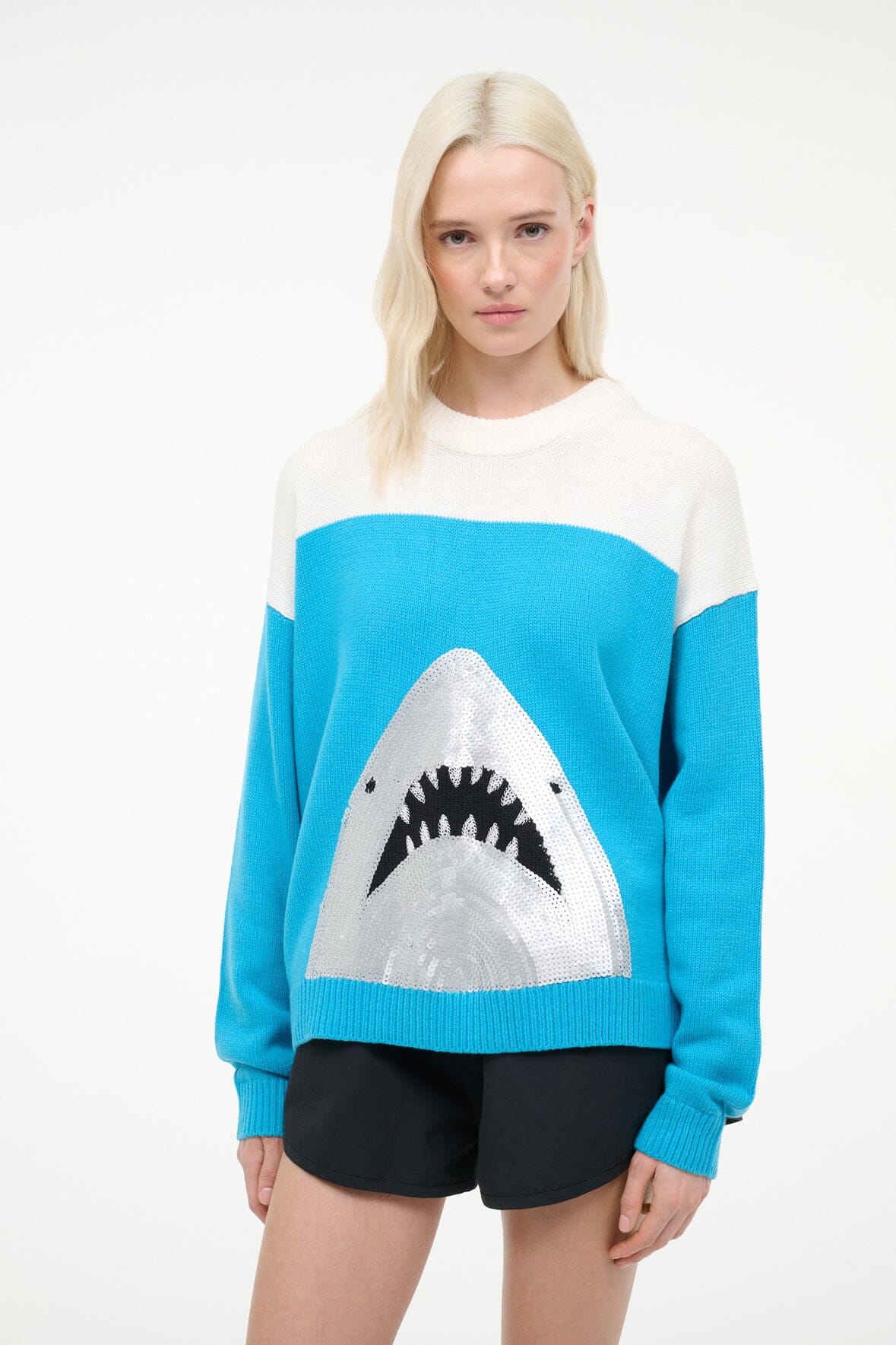 Crewneck sweater with blue body, white band, and shark graphic on front