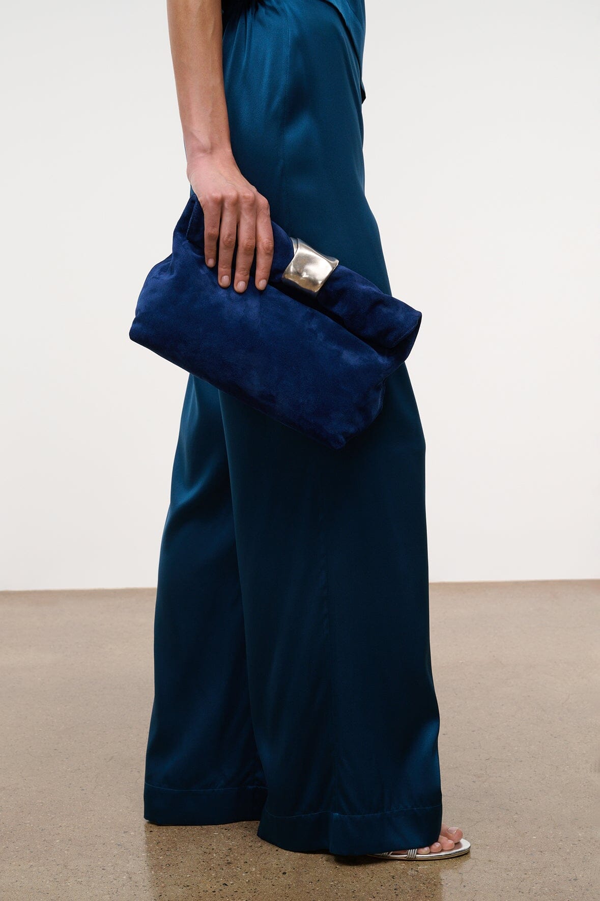 Cobalt suede cuff clutch with silver-tone front clasp, hand-held