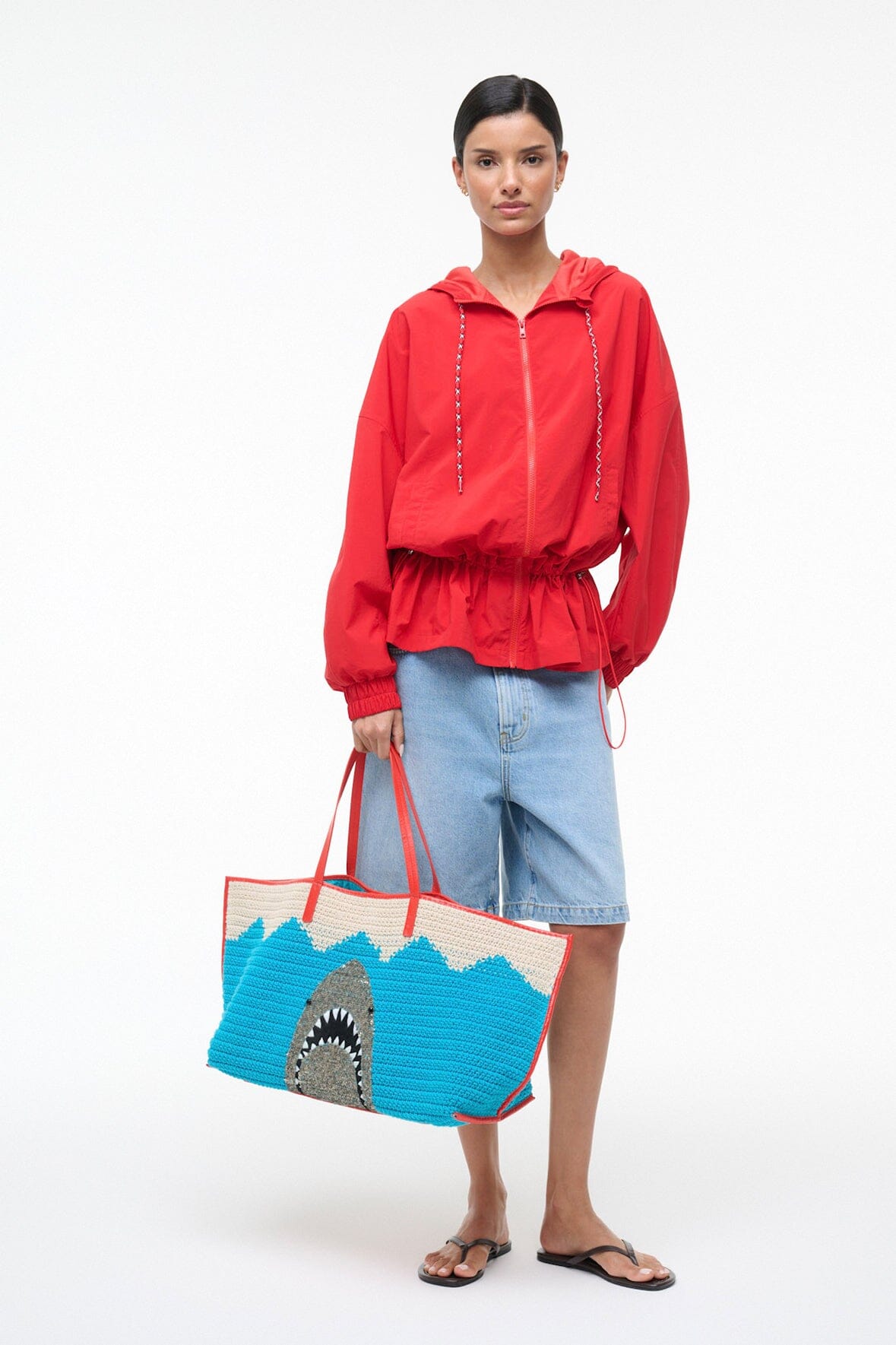 Large tote bag with blue-and-cream crocheted pattern, red drawstring handles, shark graphic