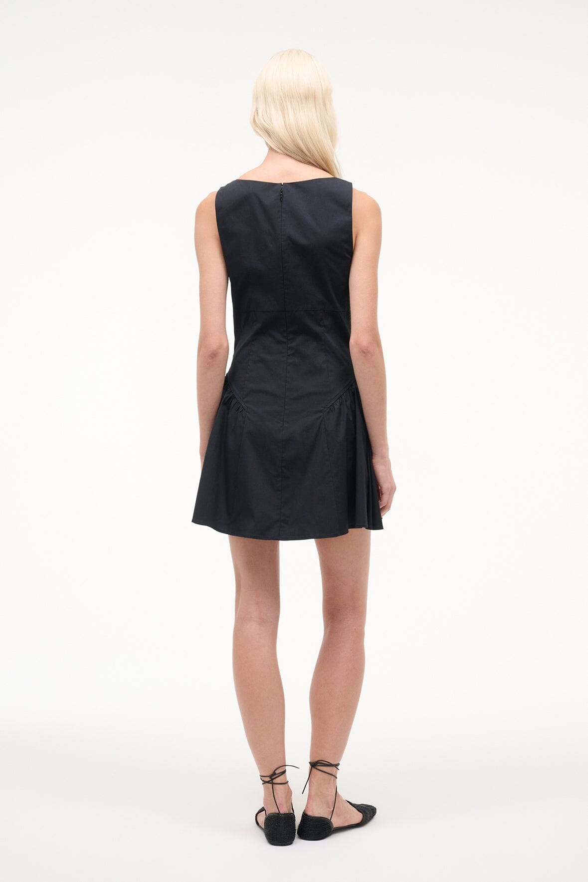 Black sleeveless mini dress, back view, gathered waist and flared skirt