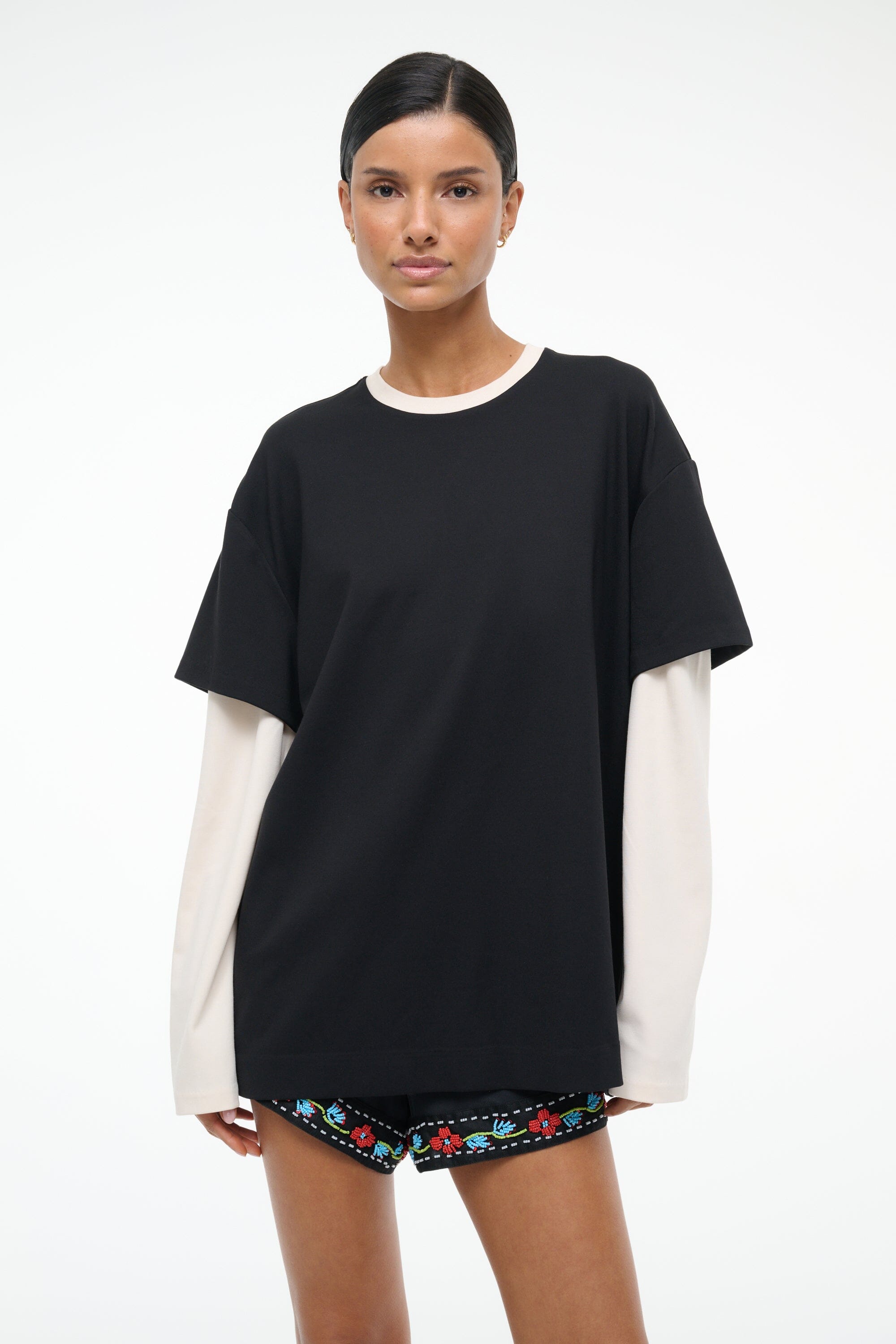 Black oversized T-shirt with white crew neckline trim and ecru underlayer sleeves