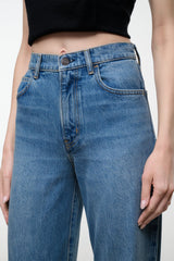 Blue denim jeans with button-and-zip closure, belt loops, side pockets, wide leg