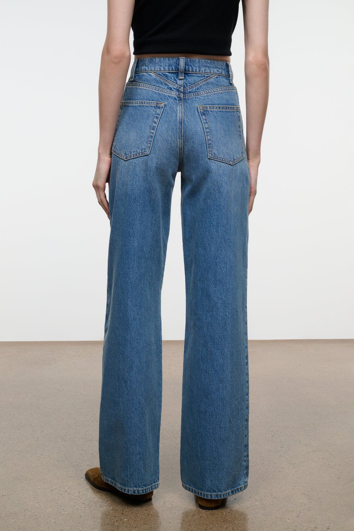Blue wide-leg denim jeans with belt loops, front patch pockets, straight hem