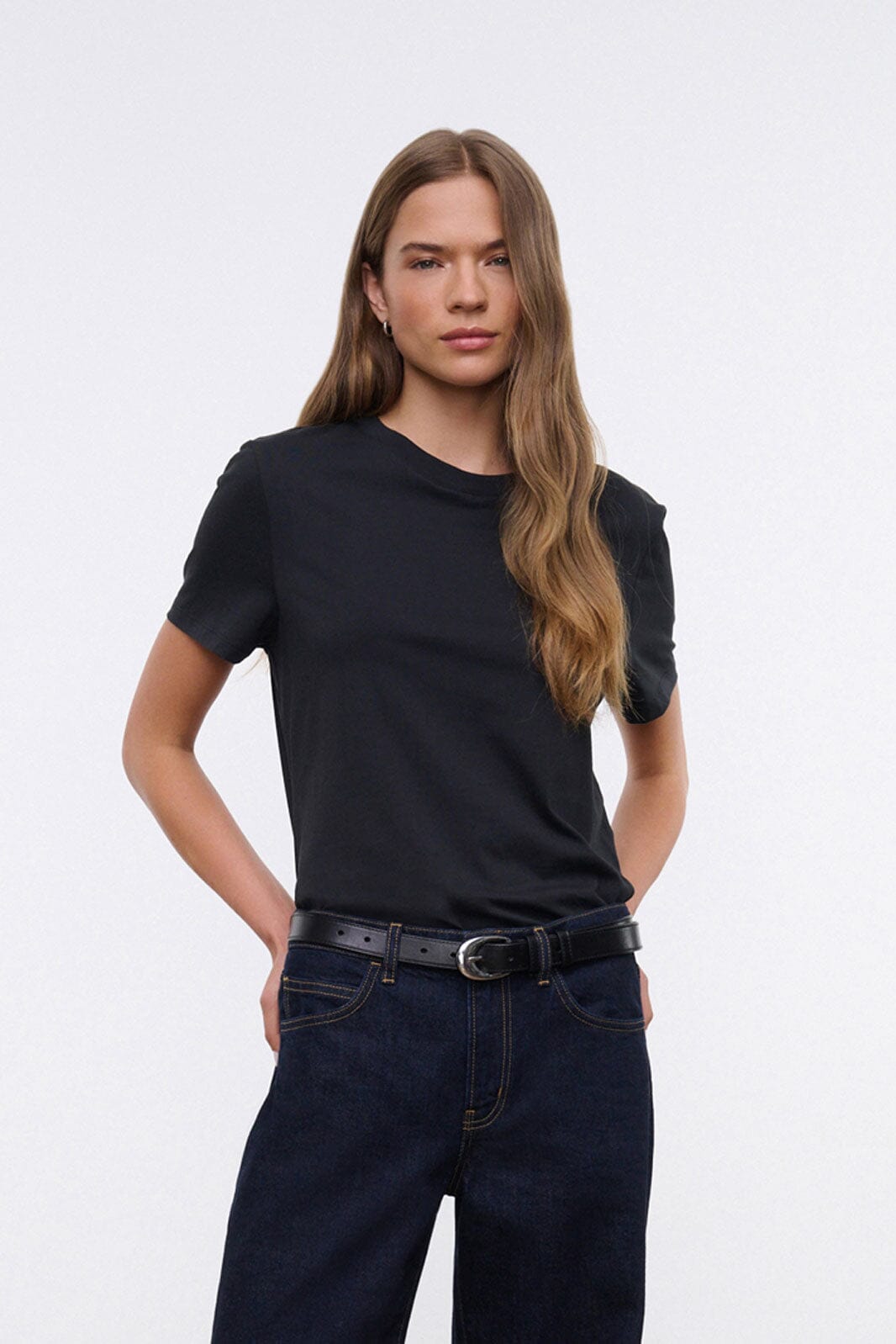 Black crew neck short-sleeve T-shirt close-up on model.