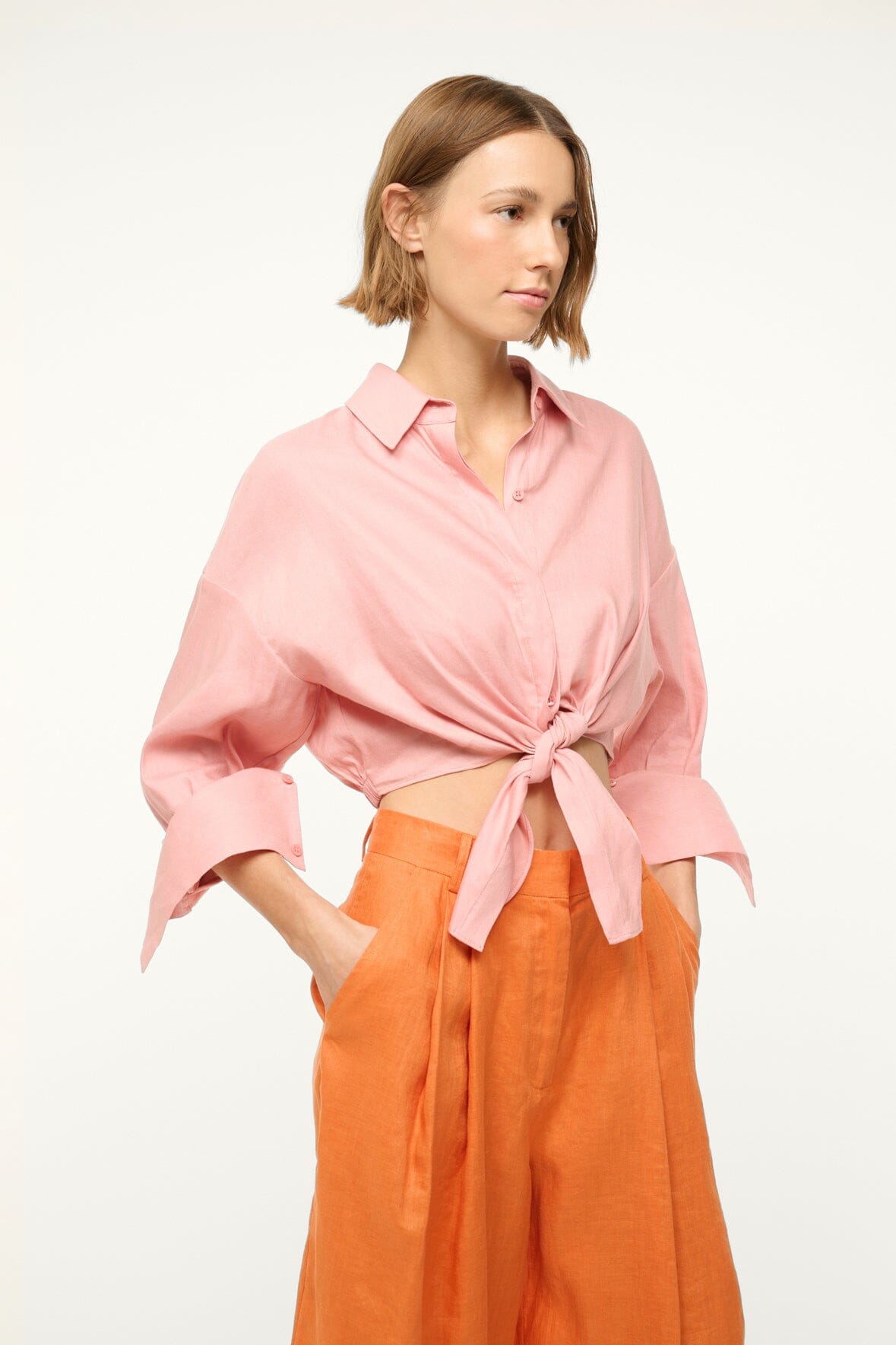 Faded blush linen button-up top with tied waist, pointed collar, and flared sleeves
