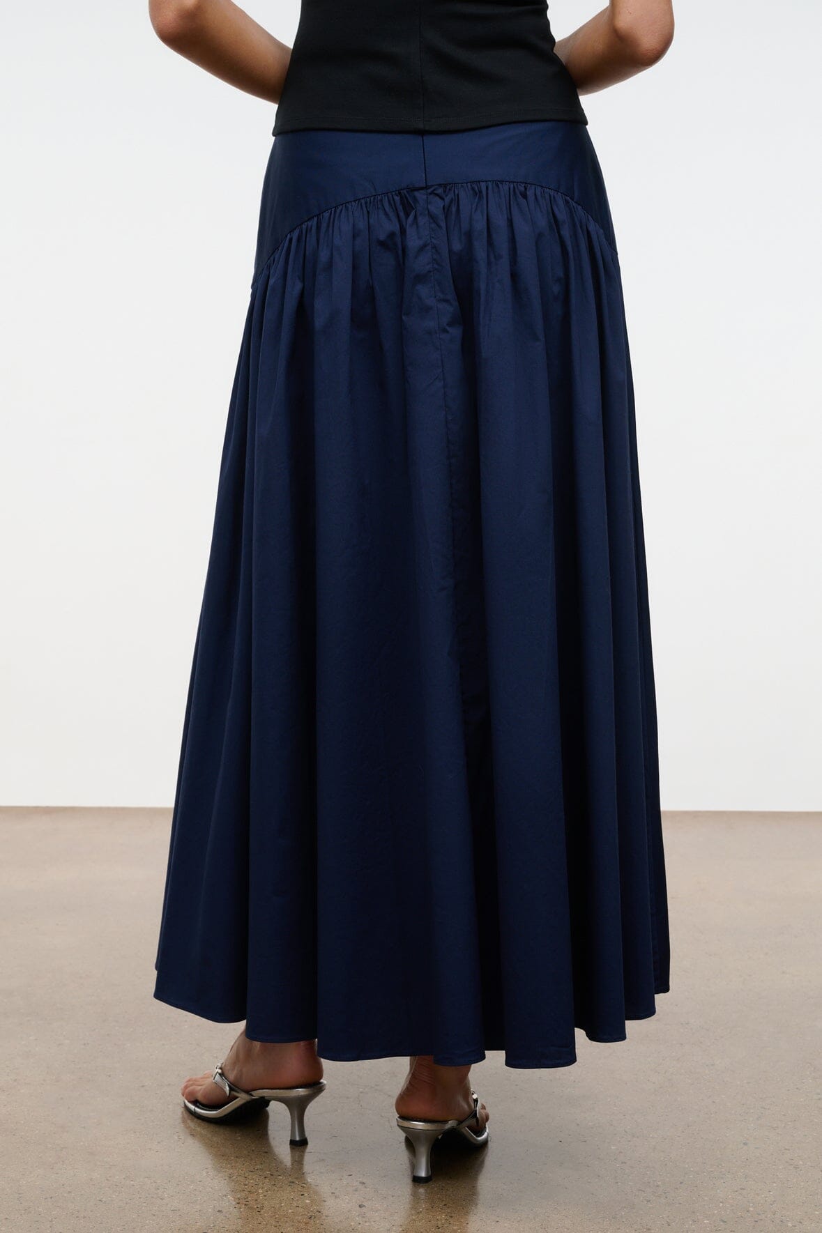 Navy pleated midi skirt with ruched elastic waistband and gathered panels