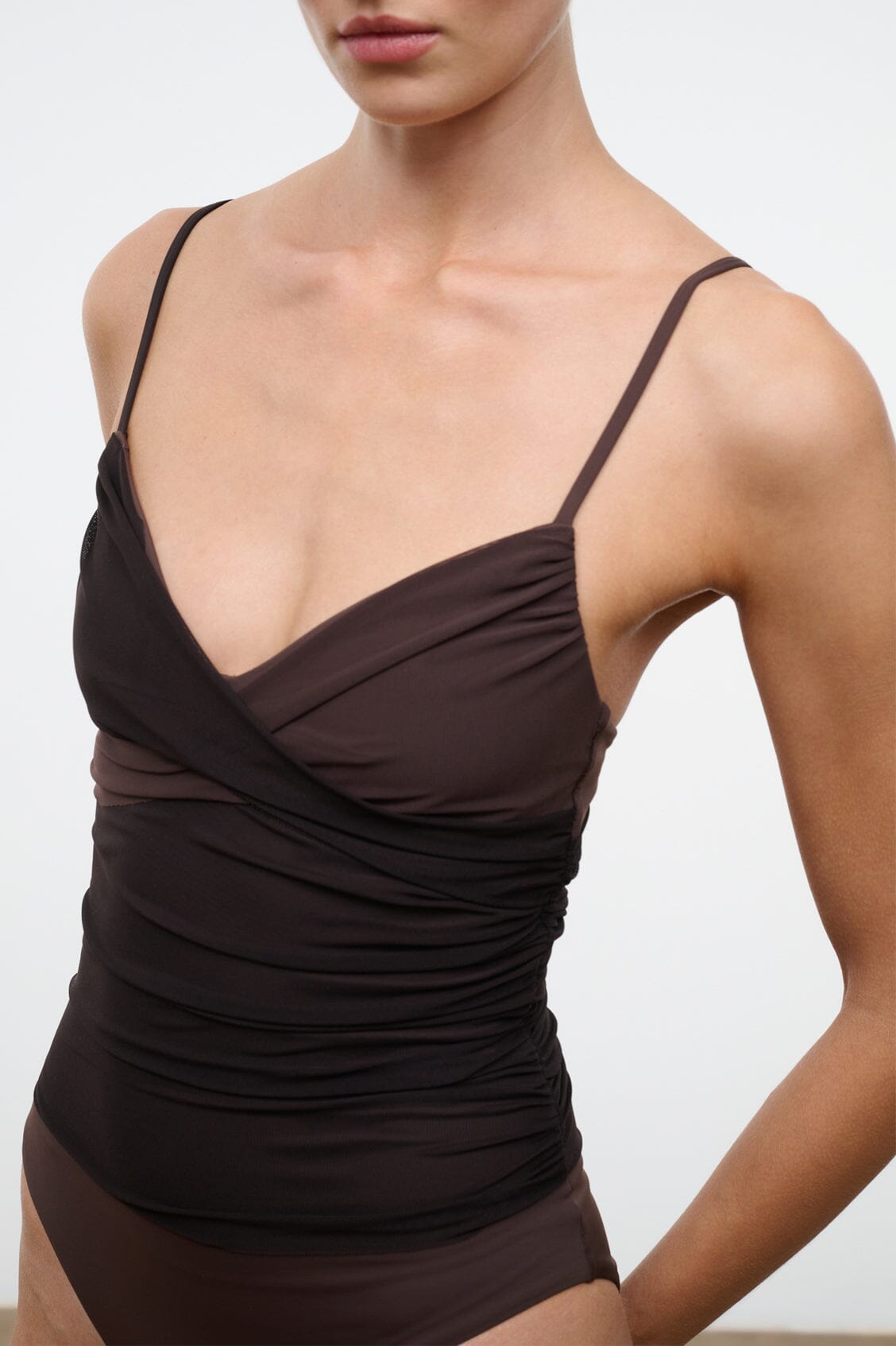 Dark brown ruched one-piece swimsuit with thin straps and draped crossover bodice