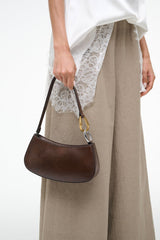 Espresso-brown Ollie hobo bag with gold ring handle, carried at the side
