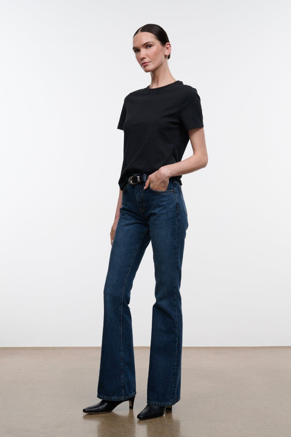 Dark indigo flare jeans with 5-pocket styling, button-zip fly, and wide flared hems