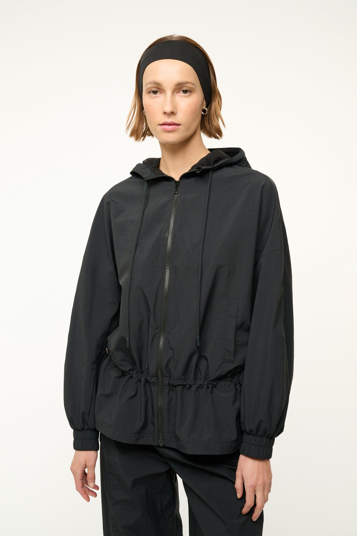 Black hooded jacket with drawstring, full front zipper, and elastic cuff hems.