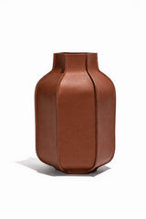 Tan leather bottle vase with rounded body and open mouth, stitched seams