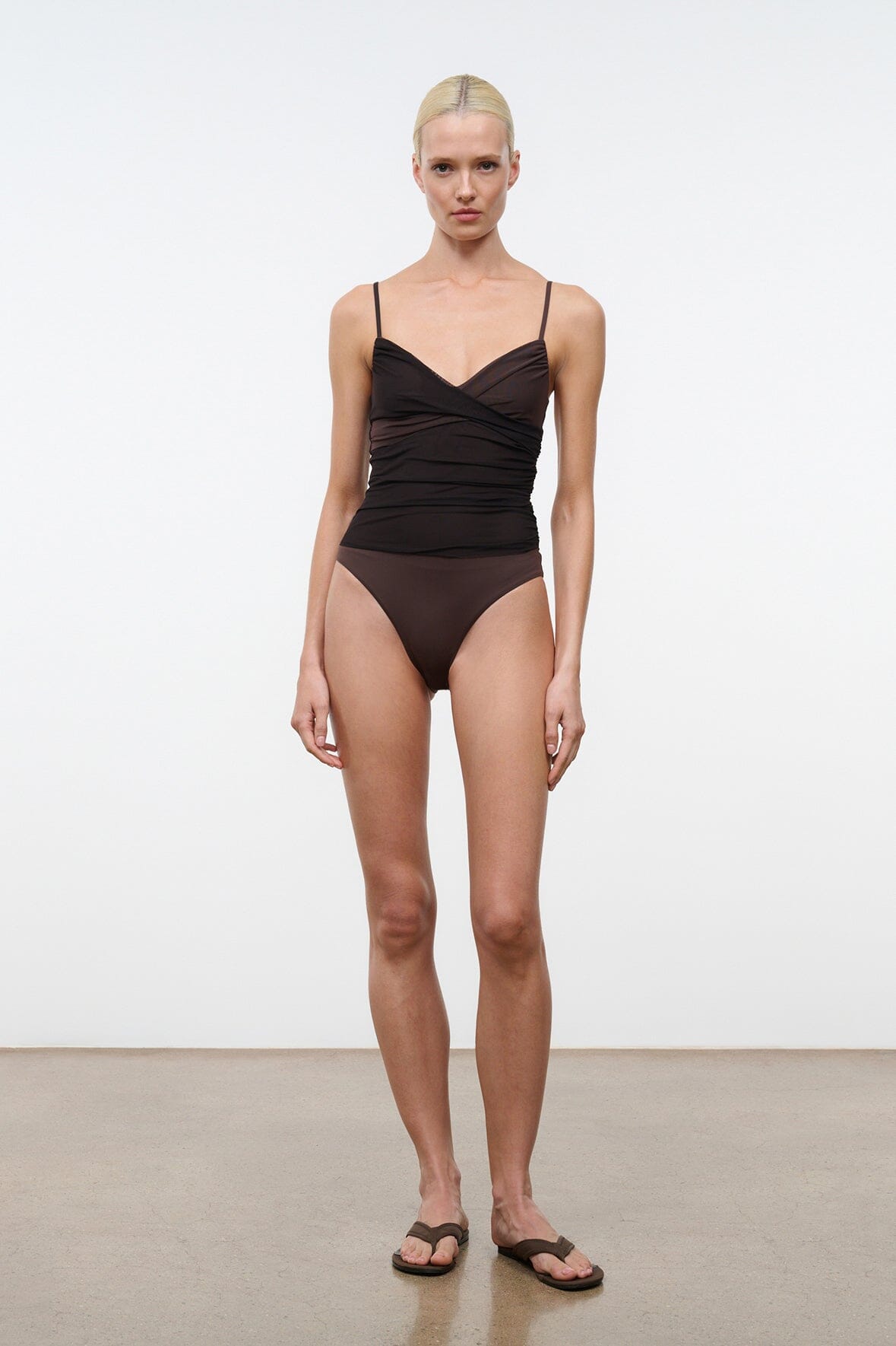 Dark brown ruched one-piece swimsuit worn model with thin spaghetti straps