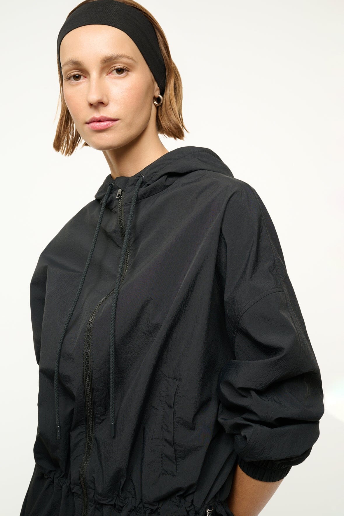 Black hooded jacket with front zipper and drawstring hem, elastic cuffs.