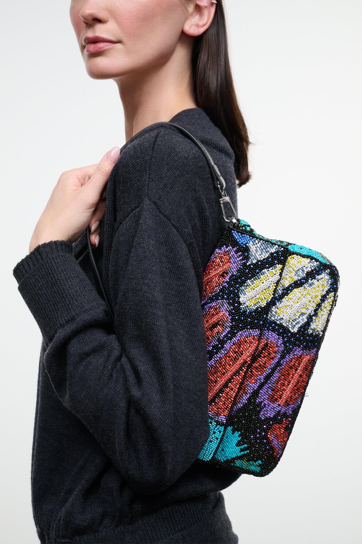 Convertible shoulder bag side view with black strap and multicolor sequin butterfly artwork