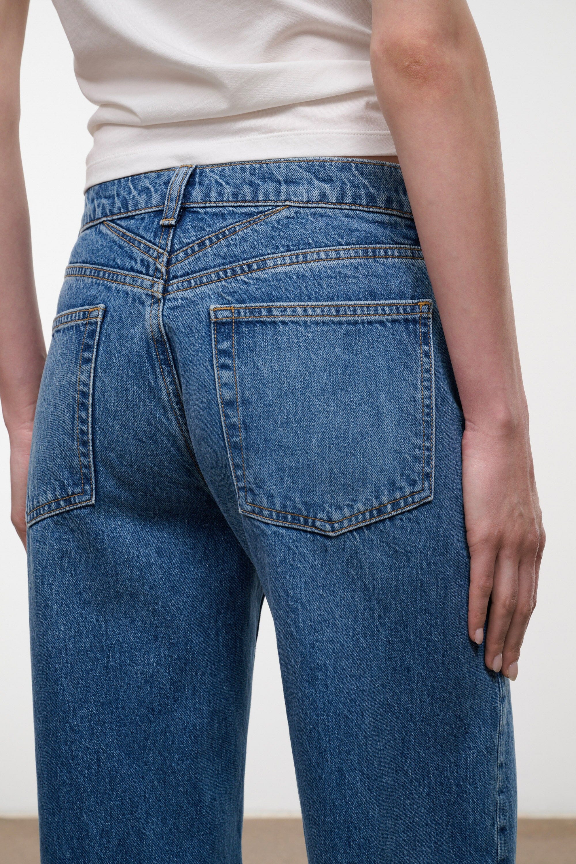 Relaxed-fit vintage wash jeans, front pocket and denim texture close-up
