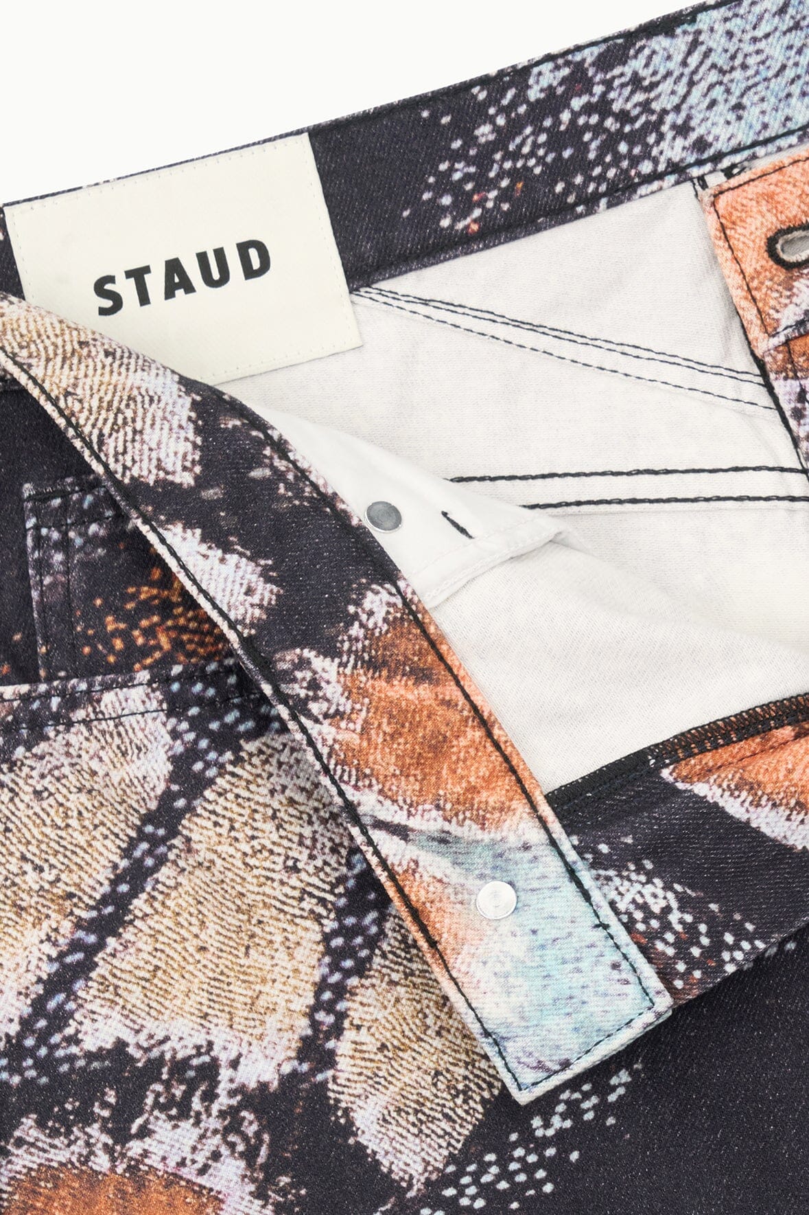 Abstract-print jeans with STAUD waistband label, button front and dark interior