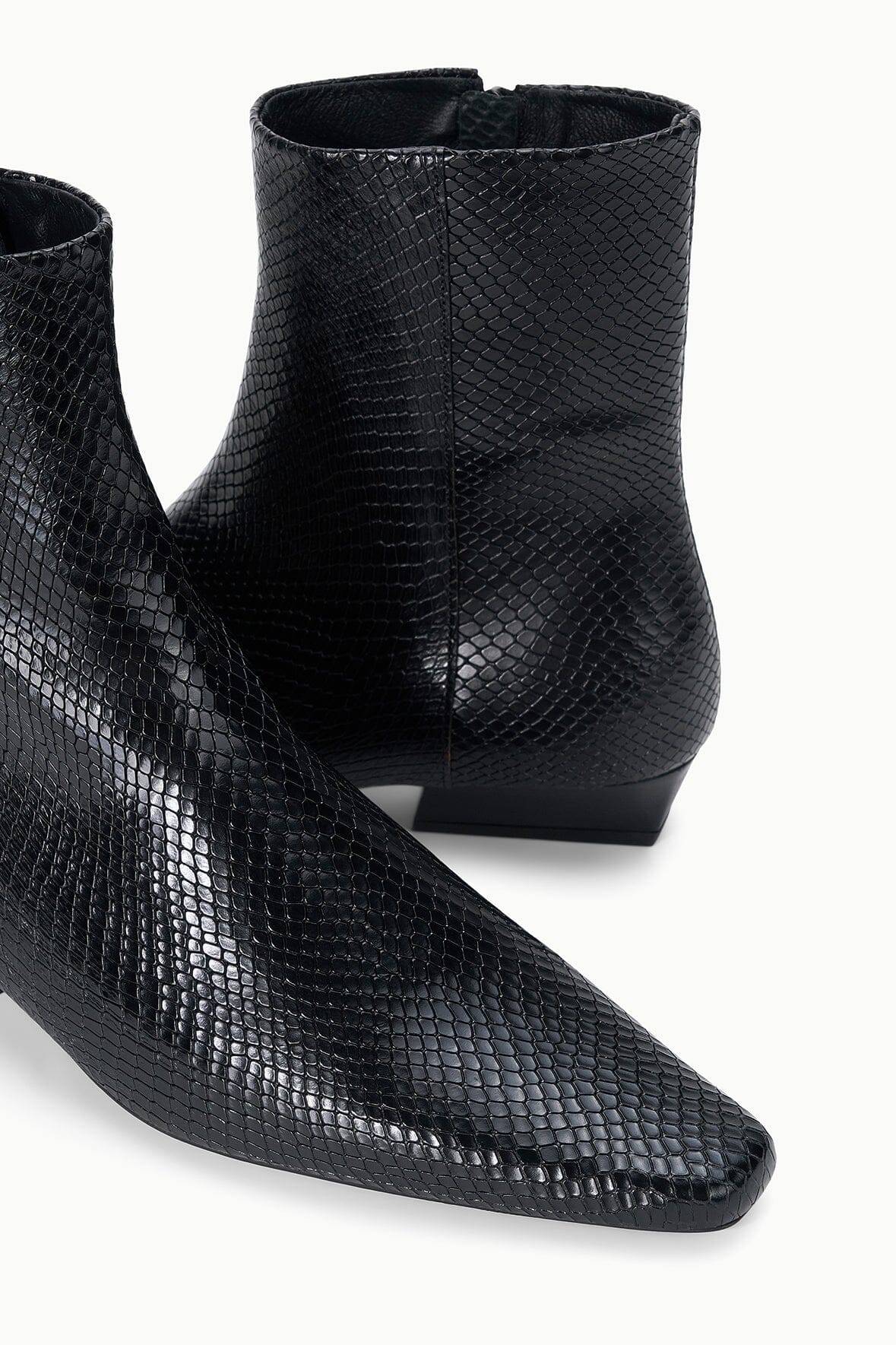 Black snake-embossed flat ankle boot inner-side view at ankle and heel