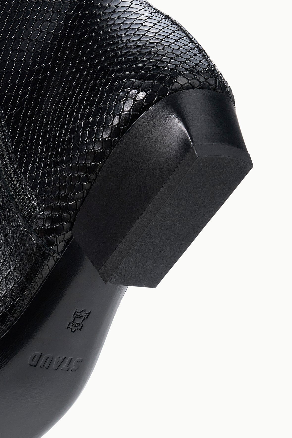 Black snake-embossed flat ankle boot heel close-up with logo on outsole