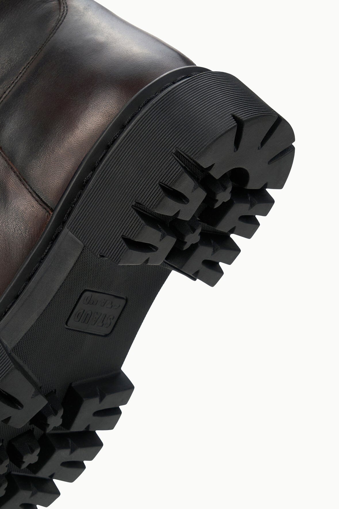 Chunky black lug boot sole with tread pattern and embossed logo detail