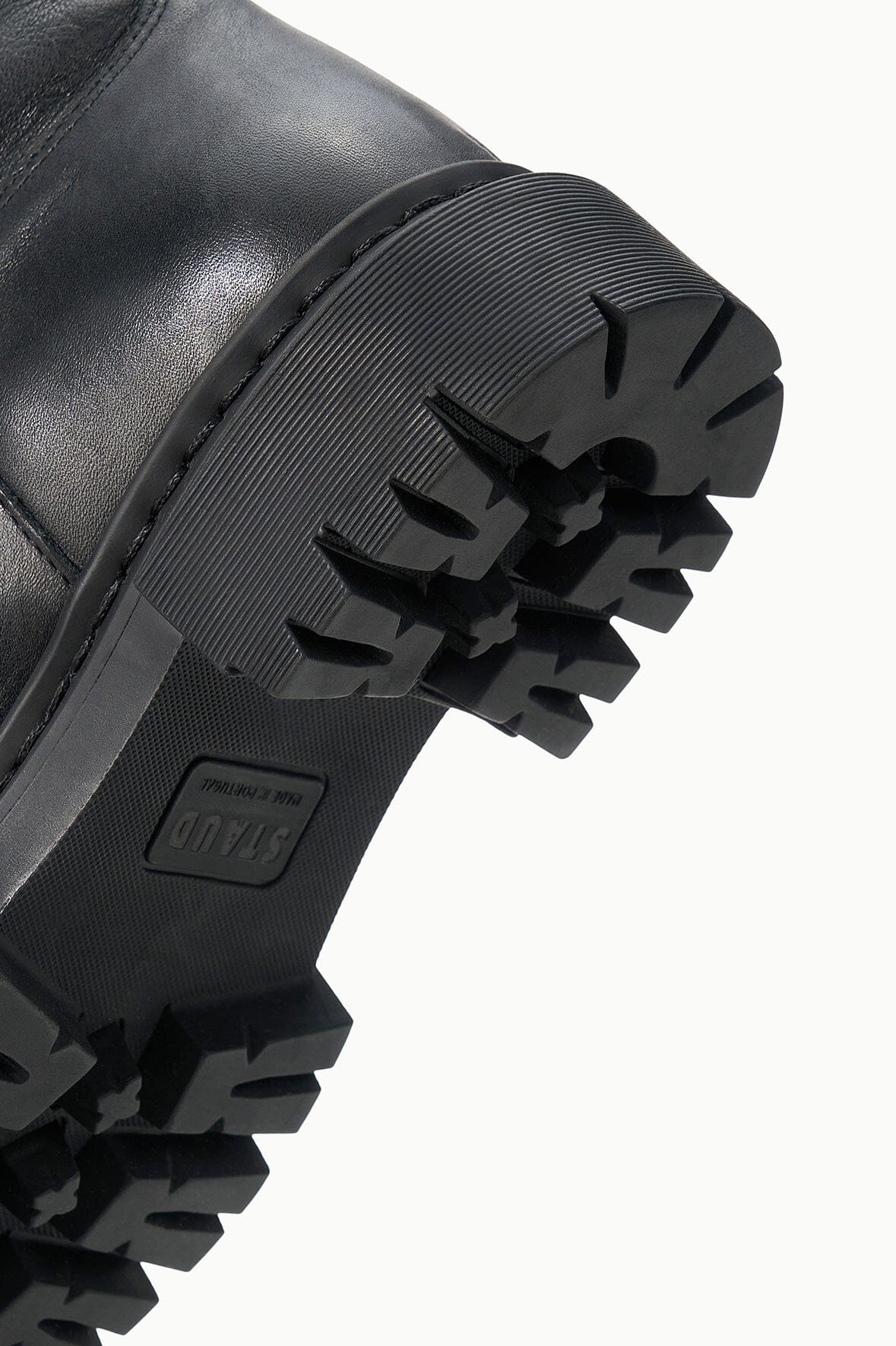 Black boot outsole tread detail with ribbed pattern and deep lugs