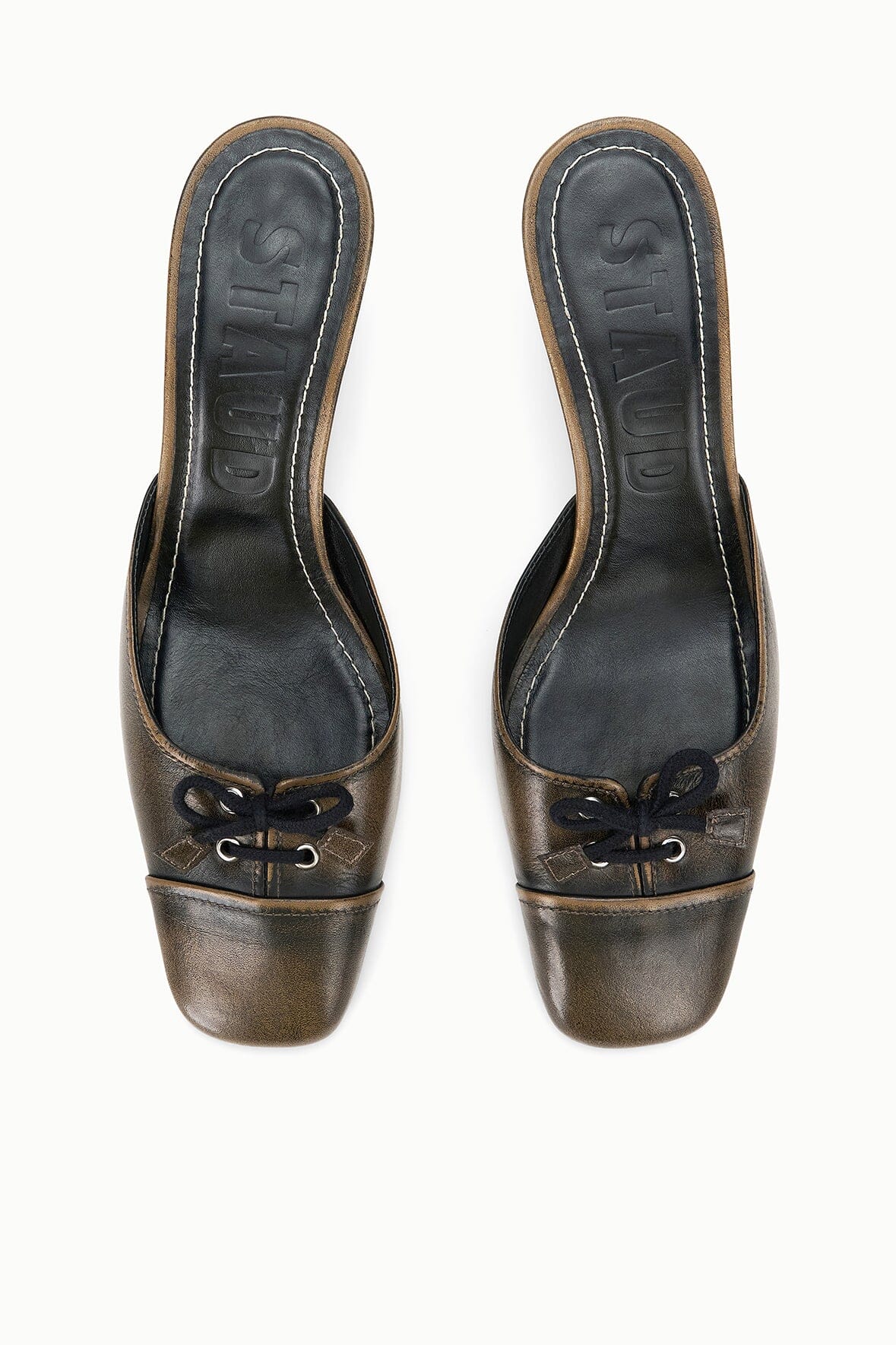 Pair of black distressed mules with pointed toe, lace-up front, and covered stiletto heel