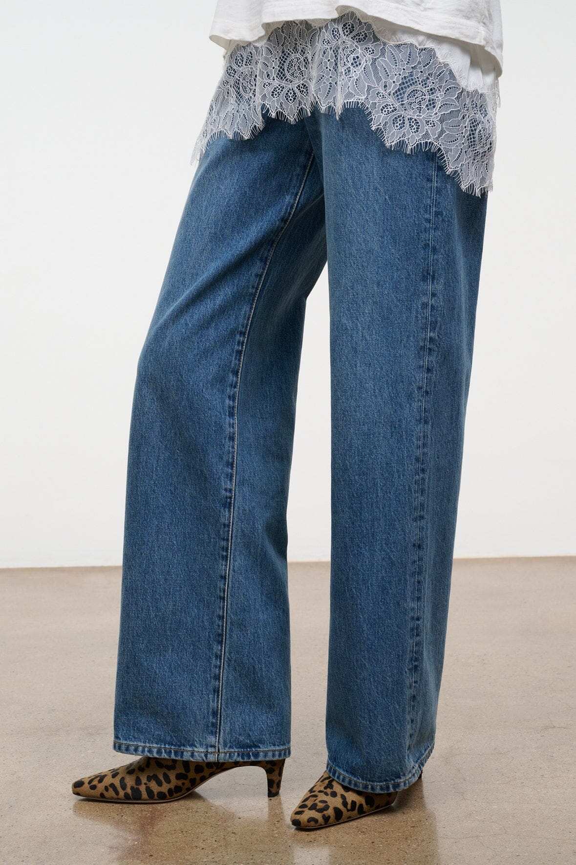 Cheetah-print ankle boots with low heel, front view with blue jeans