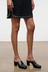 Black mule clogs with block heel, side view on model