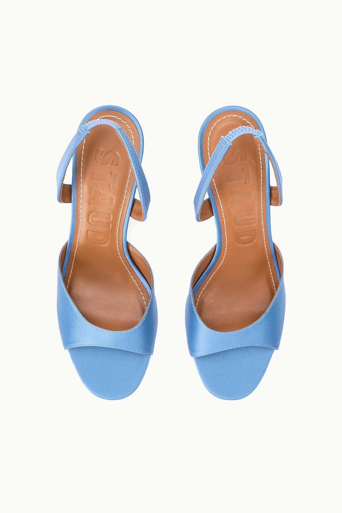 Pair of light blue satin slingback heels with open toe and ankle strap